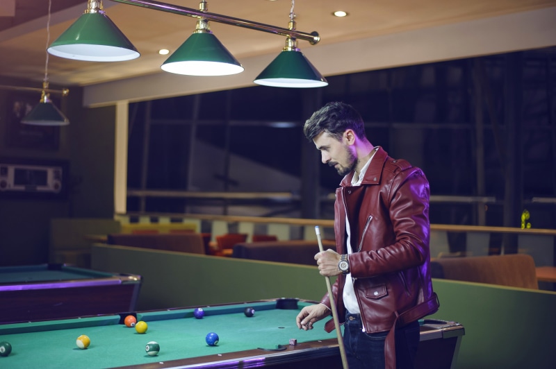 pool cue, real people, nightlife, playing, holds, pool table, indoors, pub, leisure games, concentration, holding, sport, man, arcade games, skill, relaxation