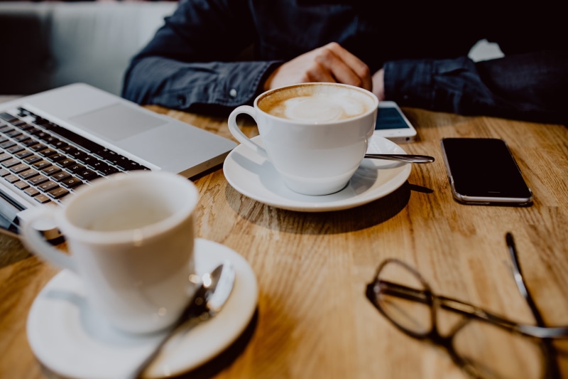 interior, mug, restaurant, one person, work, food and drink, coffee cup, working, indoors, hand, technology, saucer, coffee shop, wireless technology, adult