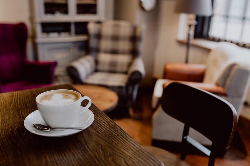 working, cafe, coffee table, table, cappucino, seat, drink, coffee - drink, mug, glass, work, hot drink, chair, food and drink, latte, focus on foreground