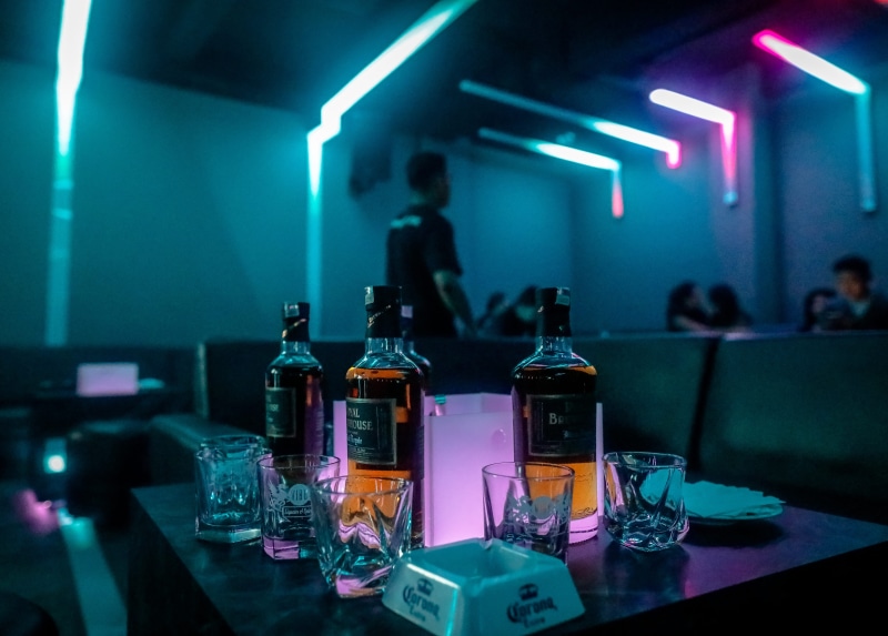 glass - material, urban, stage, human, bar counter, light, absinthe, indoors, nightclub, container, music, food and drink, incidental people, light - natural phenomenon