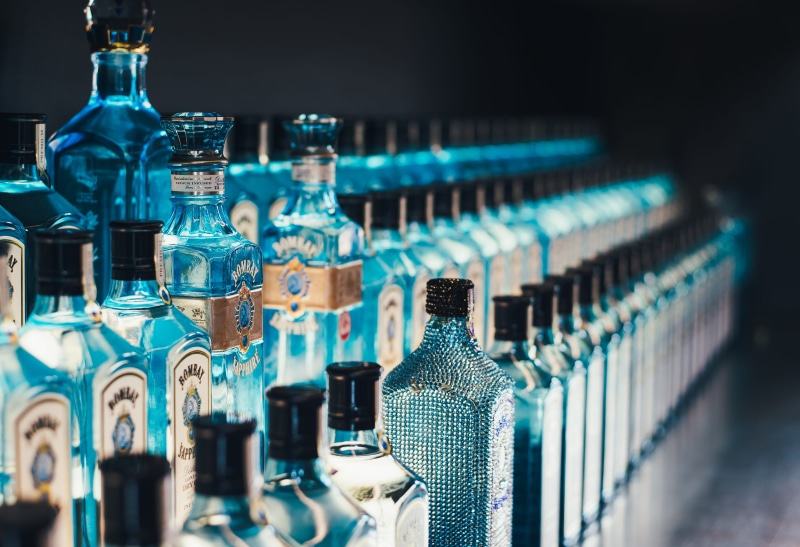 glass - material, lot, bar counter, drink, alcohol, gin, focus, bottle, indoors, food and drink, large group of objects, poisonous, in a row, bombay sapphire