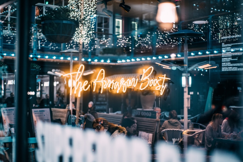 built structure, cafeteria, food court, lighting equipment, night life, dining, person, selective focus, women, bazaar, club, sign, business, market, inside