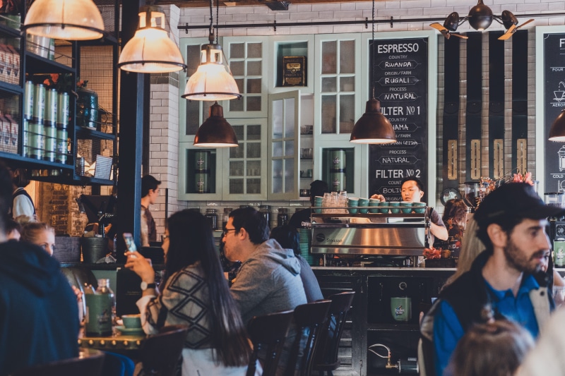 building exterior, group of people, adult, group, coffee shop, city life, crowd, leisure activity, market, eating, local, tea, vintage, social, architecture