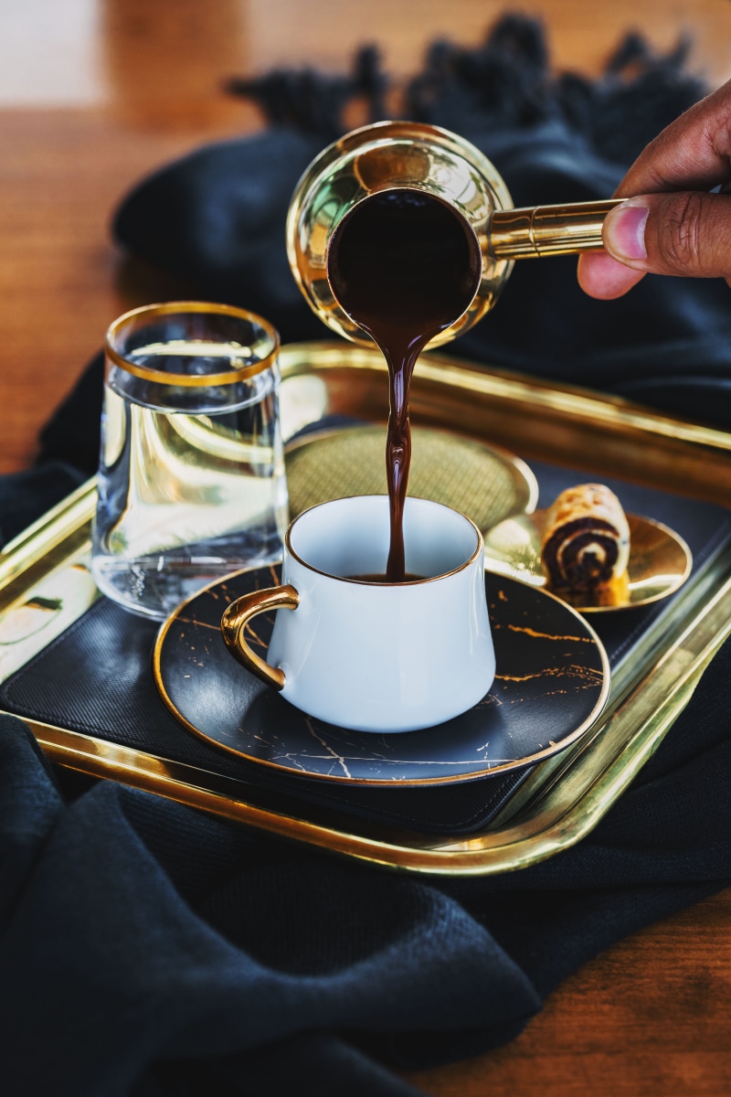 unrecognizable person, one person, human hand, glass, caffeine, hotcoffee, coffee, eating utensil, body part, table, human finger, human, latte, espresso