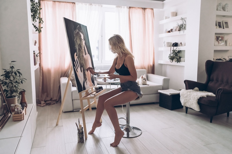 women, one person, hair, chair, beautiful woman, furniture, seat, jean shorts, adult, day, plants, easel, fashion, hairstyle, sitting, side view, window