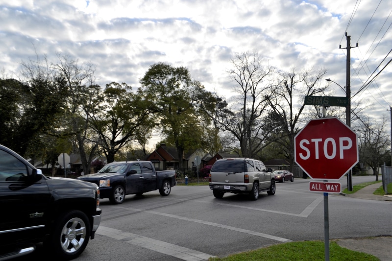 city, driving, intersection, caution, flowing, direction, mode of transportation, no people, road sign, daytime, neighborhood, street, traveling, crowded