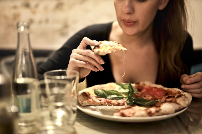 holding, plate, adult, one person, snack, food, glass, girl, unhealthy eating, business, woman, drink, hairstyle, young adult, dining, pizza, eating, restuarant