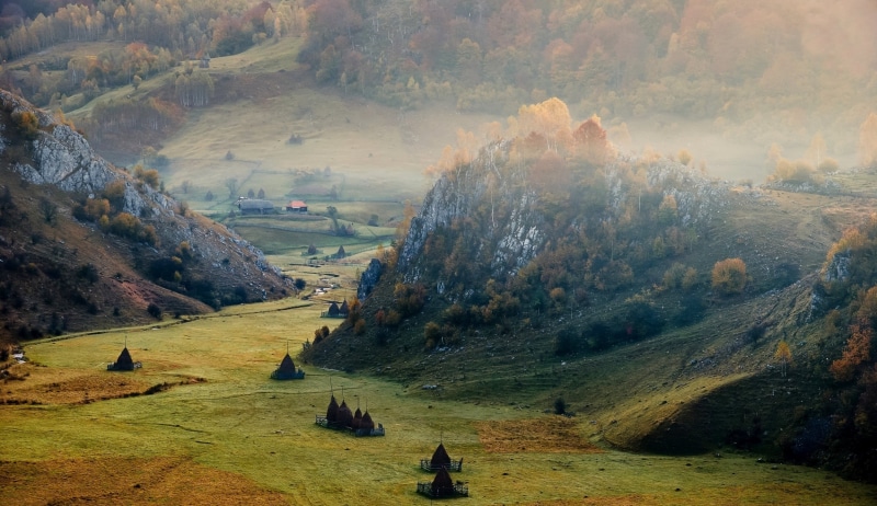 high angle view, valley, tranquil scene, nature, trees, land, mountain, outdoors, mist, day, mountains, sunlight, villages, forest, beauty in nature, scenics - nature