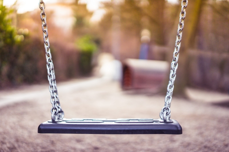 city, day, outdoor play equipment, metal, Swing, City Park, hanging, close-up, focus on foreground, fun, tree, park, absence, sunlight, woods, playing