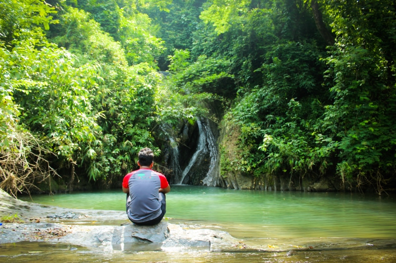 one person, nature, beauty in nature, flowing water, lifestyles, water, casual clothing, outdoors, tracking, waterfall, forest, real people, day, rear view