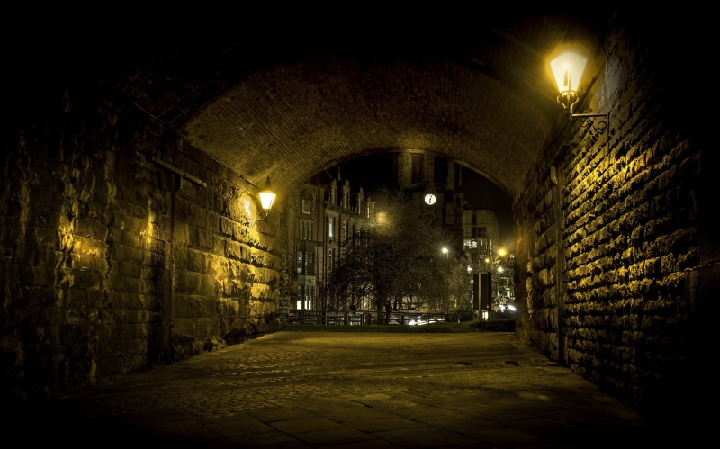 clock tower, electric lamp, buildings, 2K, footpath, tunnel, dark, building, direction, walls, illuminated, no people, lamps, brick, sconce, road, brown