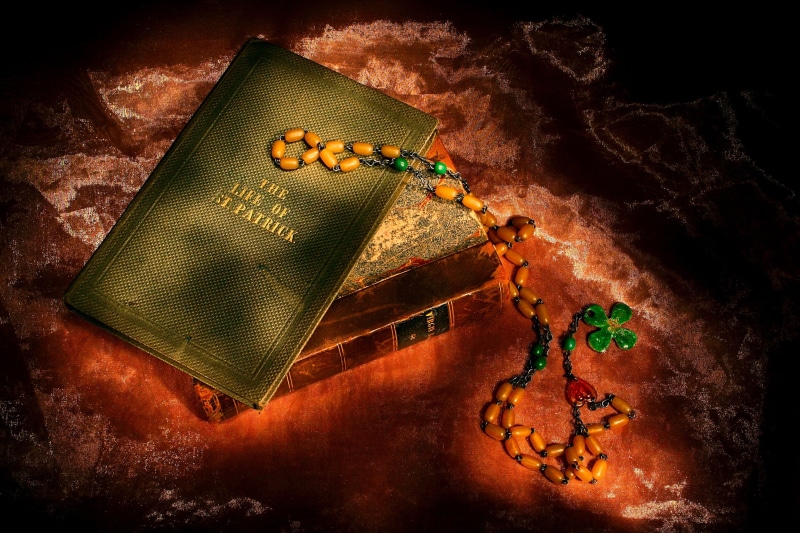 spirituality, holiday, studio shot, shamrock, communication, saint, warm, bible, still life, celebration, book, ireland, food, rich, black background, gold colored