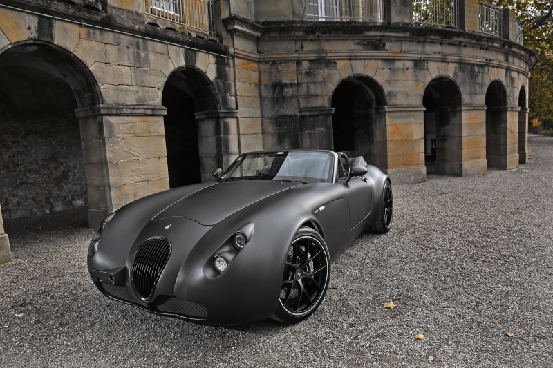 sports, car, motor vehicle, no people, building exterior, matte paint, 2K, gray, outdoors, vintage car, day, built structure, retro styled, arch, abandoned