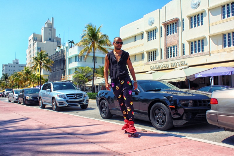 parked cars, skateboarding, day, street, transportation, miami, person, motor vehicle, tourism, riding, front view, transportation system, town, lifestyle