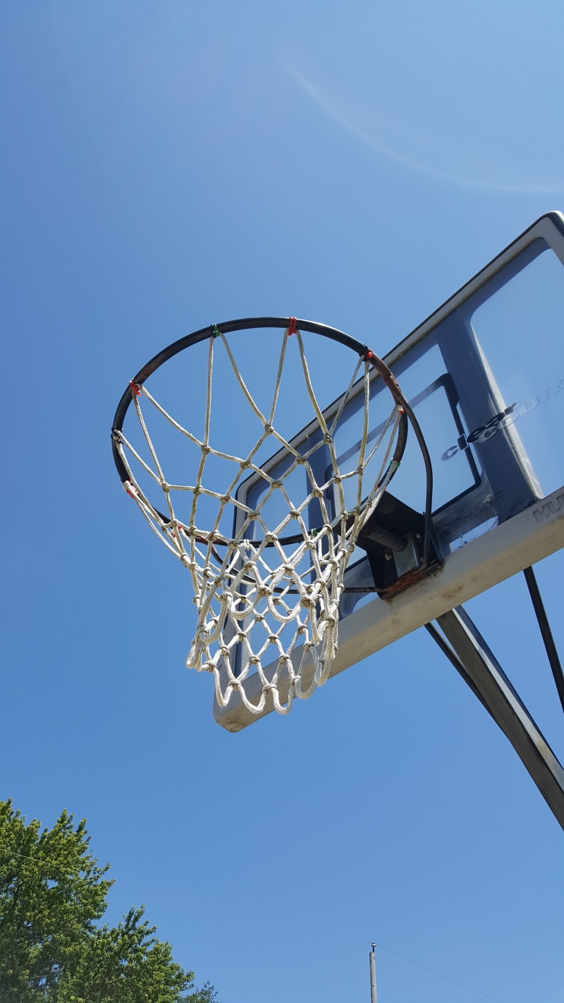 no people, leisure games, competition, net, sky, clear sky, backboard, hoop, net - sports equipment, blue, day, shot, outdoors, tree, basket, sunlight