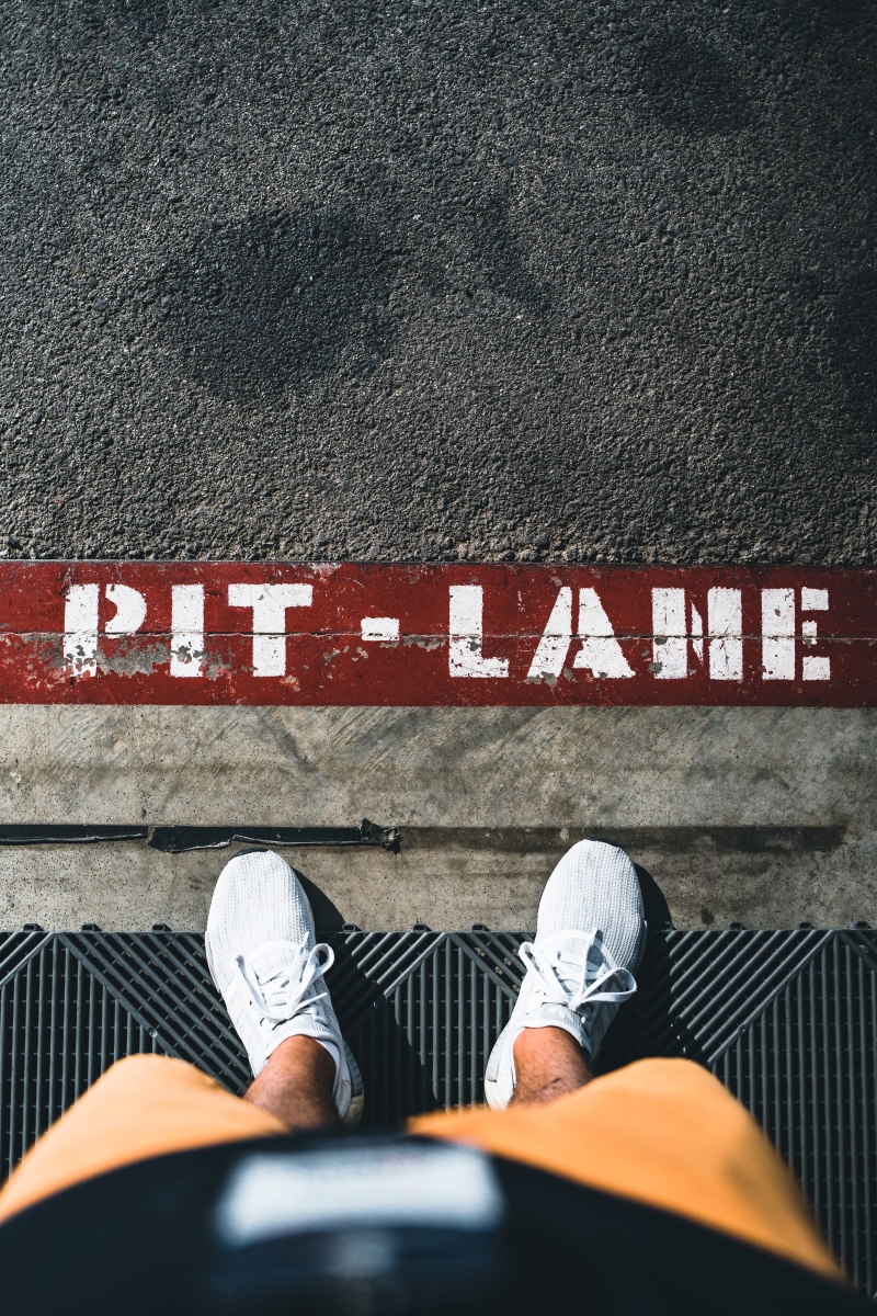 human limb, sign, outdoors, day, sneaker, tire, alloy wheel, jeans, human, 5K, running shoe, shoe, asphalt, high angle view, road, real people, human body part