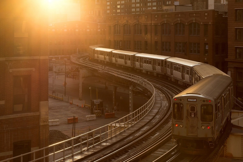 public transportation, city life, on the move, tail light, white, display, no people, window, railroad track, city, built structure, evening, sunlight
