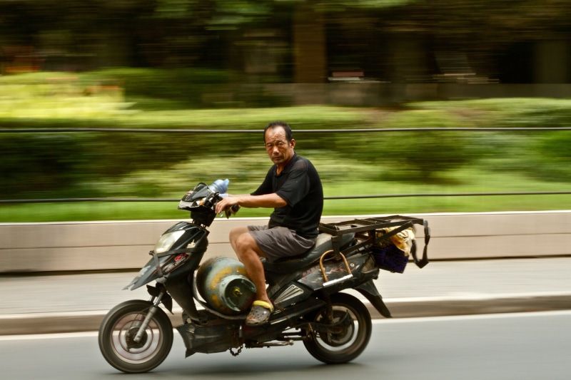 mode of transportation, trees, mature adult, old, casual clothing, young at heart, biker, road, transportation, gas, blurred motion, tank, one person, side view
