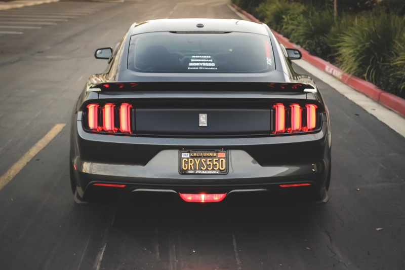 architecture, garage, transportation, land vehicle, driving, muscle, text, retro styled, mustang, city, black car, street, travel, road, car light, detail