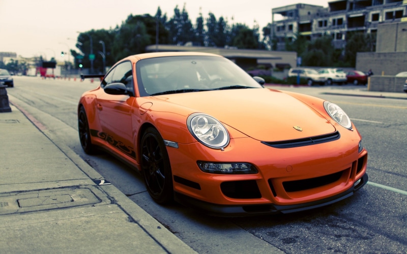 motor vehicle, Porsche 911 GT3 RS, focus on foreground, building exterior, vintage car, transportation, 2K, road, red, outdoors, land vehicle, orange cars