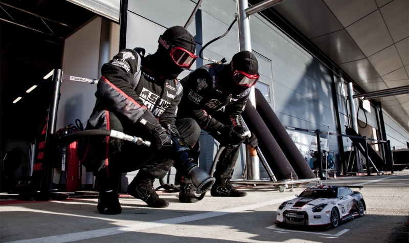 headwear, nissan, two, people, helmet, transportation, medium group of people, motion, real people, day, car, racing, Nissan GT-R NISMO, group, r, person