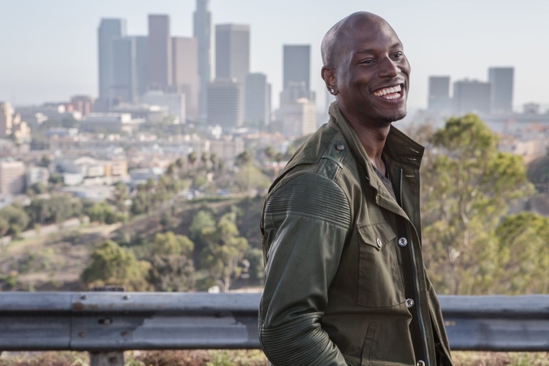 lifestyles, jacket, built structure, smiling, Roman Pearce, males, 1080P, leisure activity, railing, waist up, looking away, one person, real people, Fast and Furious