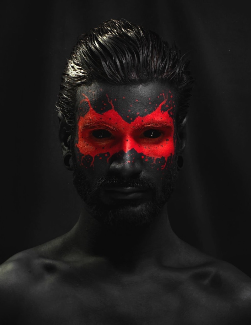 indoors, red, black background, 720P, human face, front view, portrait, studio shot, selective coloring, model, body paint, looking at camera, adult, isolated color