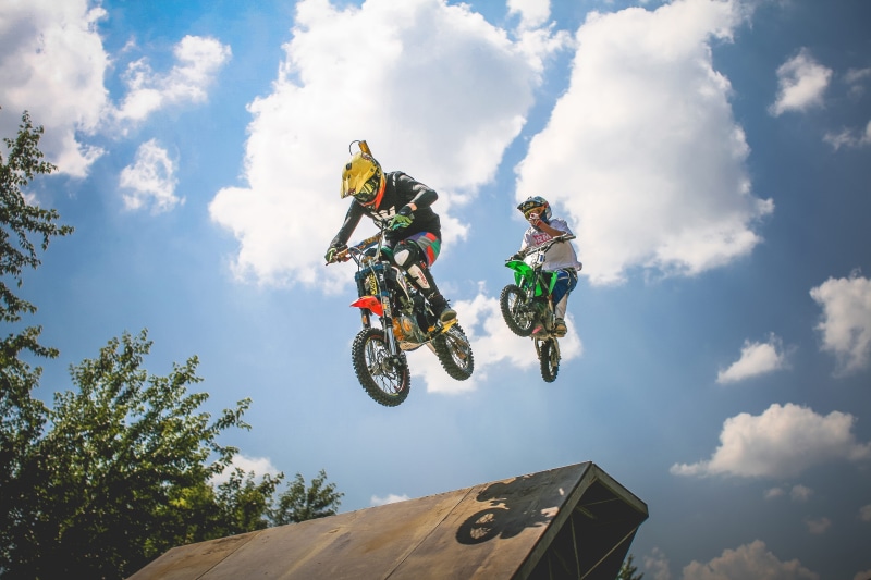 cloud - sky, two, men, action, transportation, speed, motorcycle, cycling, stunt, people, extreme Sports, leisure activity, outdoors, headwear, adventure