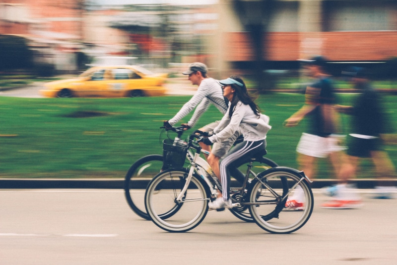 road, man, transportation, beside, architecture, cyclist, woman, street, sport, activity, bike, car, travel, mode of transportation, city, exercise, speed