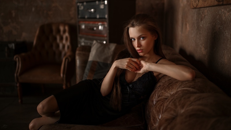 black clothing, sitting, blue eyes, 2K, long hair, Yuriy Lyamin, brunette, couch, Fenix Raya, Phoenix Raya, dress, cleavage, women, sideboob, face