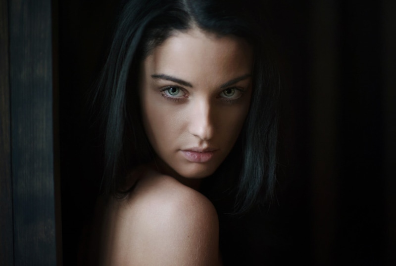 hair, looking at camera, adult, indoors, sadness, hairstyle, black background, beauty, human body part, portrait, emotion, 1080P, close-up, brunette, studio shot