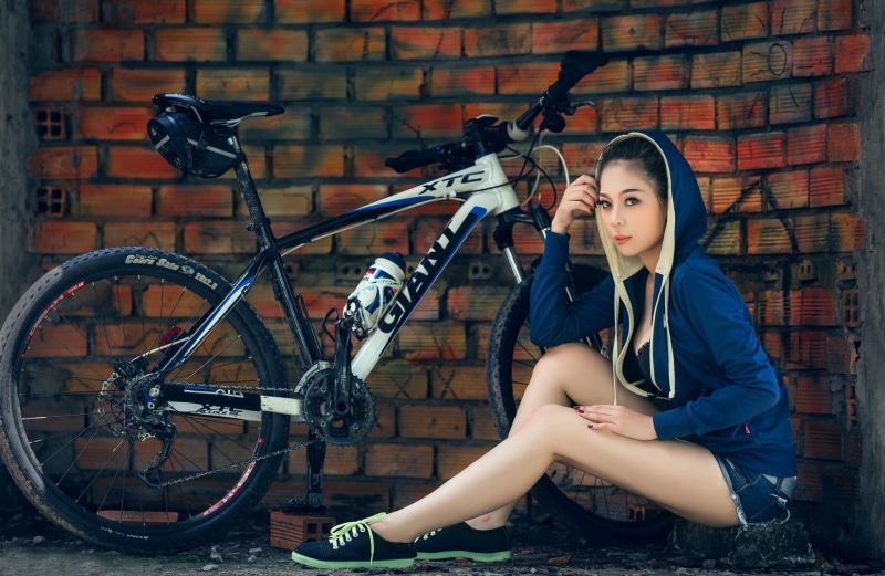 women, people, wheel, looking at viewer, brunette, brick wall, lifestyles, jean shorts, adult, legs, sitting, beautiful woman, wall, beauty, hoods, fashion