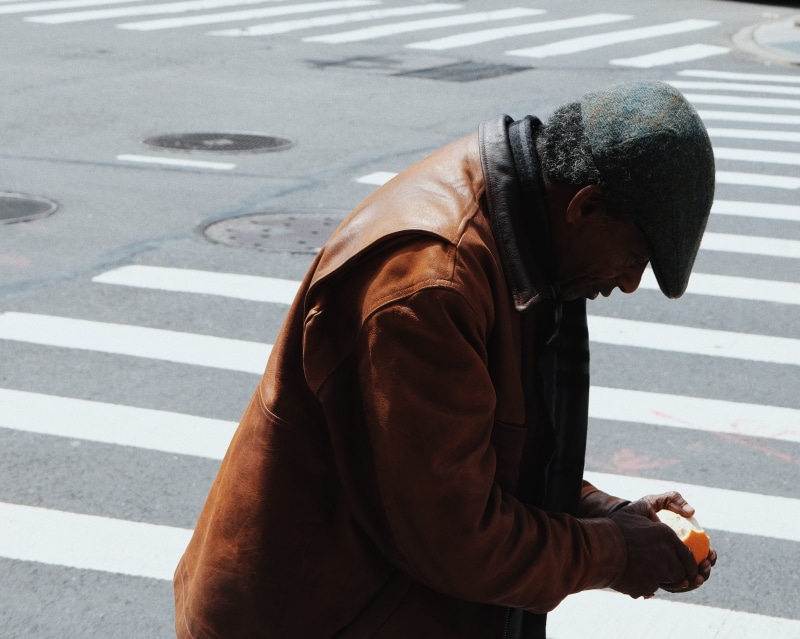 single, one person, walking, wearing, new york, shadow, men, symbol, hat, lifestyles, jacket, pedestal, road marking, three quarter length, peeling, social issues