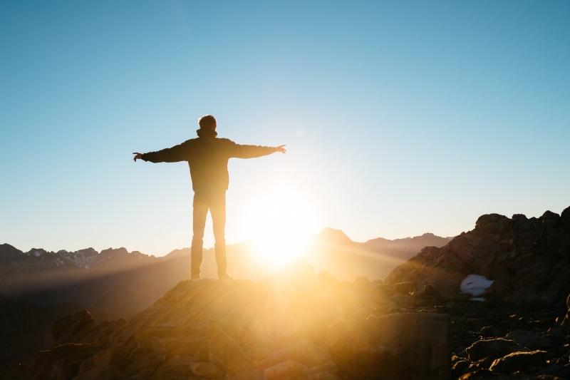rocks, sky, rock, looking at view, one person, sport, sunrise, alone, nature, blue, mountain, hiking, arms outstretched, sun, silhouette, human limb, achievement