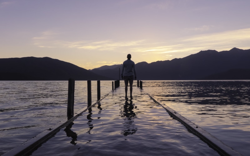 mountain range, beauty in nature, relaxation, sunrise, rear view, water, mountain, ocean, simple living, sky, travel, men, silhouette, people, calm, underwater