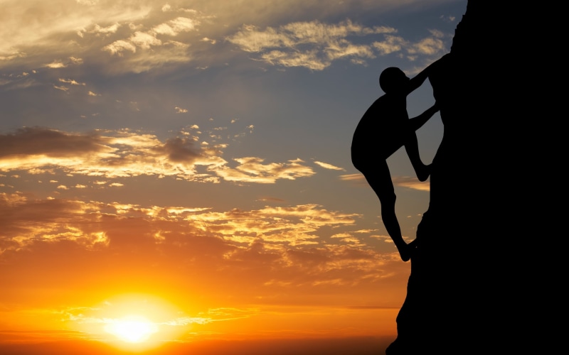 sunlight, lifestyles, outdoors, scenics - nature, rock climbing, beauty in nature, nature, climbing, sun, one person, standing, sky, mountain, silhouette