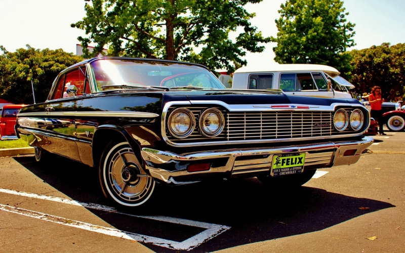 land vehicle, car, plant, Oldtimer, road, day, nature, headlight, stationary, outdoors, 1080P, black, mode of transportation, coupe, motor vehicle, chrome
