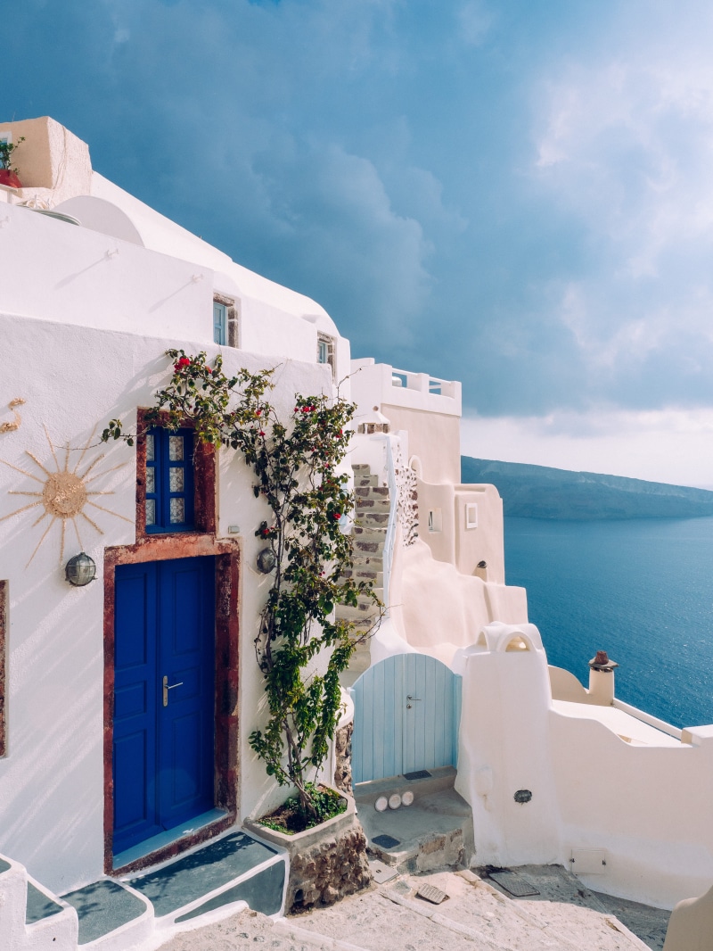 water, outdoors, door, daytime, body, sky, seaside, oium, sunlight, white, no people, white color, vine, cloud - sky, near, santorini, built structure