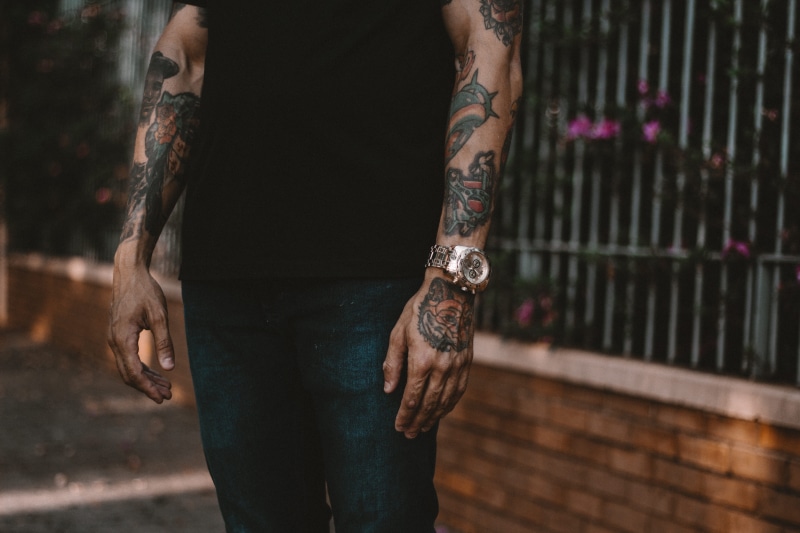 person, urban, casual clothing, clock, fashion, man, men, midsection, shirtless, body part, boy, fence, natural, close in, human limb, nearby, focus on foreground