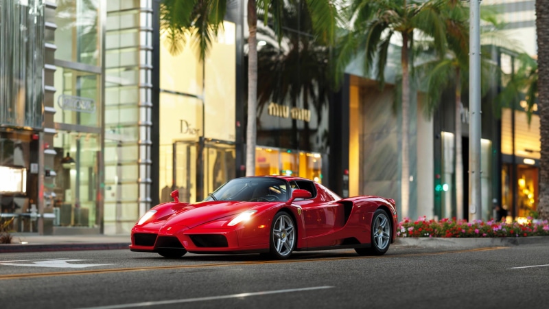 outdoors, on the move, building exterior, motor vehicle, red, hatchback, wheel, palm trees, Ferrari, day, luxury, tree, palm tree, Ferrari Enzo, door, road
