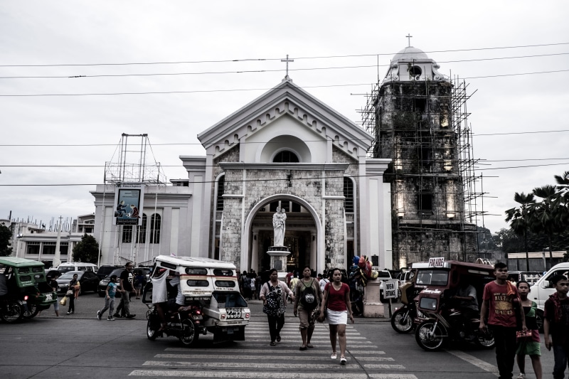 real people, black, transportation, urban, men, built structure, cable, street, chruch, building exterior, car, white, bohol, incidental people, sky, city