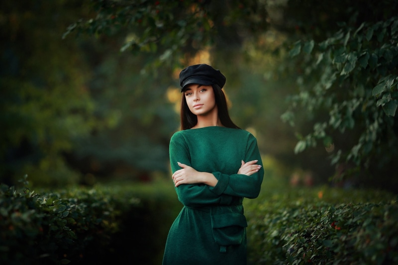 model, depth of field, berets, women outdoors, dress, brunette, leaves, arms crossed, Dmitry Arhar, Bushes, women, looking at viewer, 1080P, outdoors
