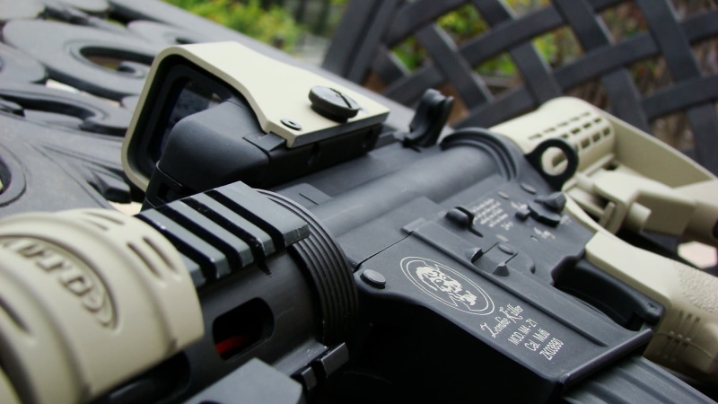 protection, 1080P, outdoors, gray, focus on foreground, close-up, rifle, metal, government, machine gun, land vehicle, transportation, gun, selective focus