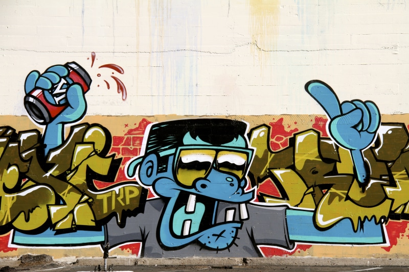 5K, male likeness, art and craft, built structure, representation, text, wall - building feature, finger pointing, monkey, outdoors, human representation