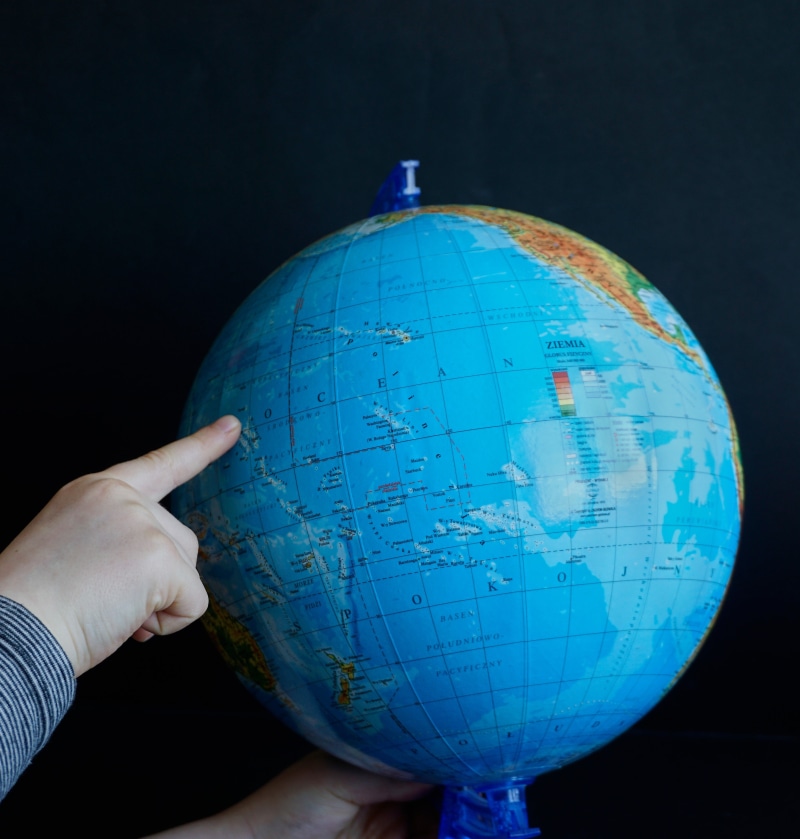 person, desk, globe, human body part, physical geography, real people, exploration, ocean, globus, map, travel, planet earth, holding, draw, hand, black background