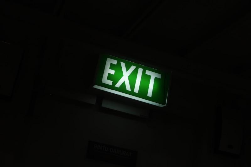 directional sign, green color, leaving, arrow symbol, emergency, night, black background, sign, dark, guidance, communication, safety, indoors, emergency exit