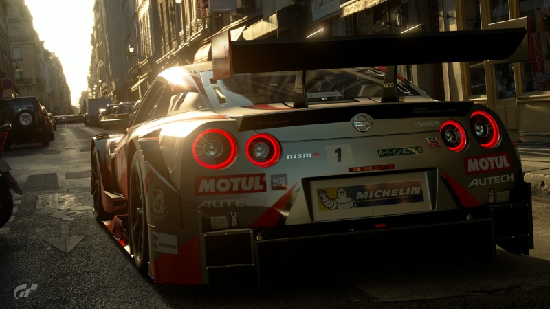 Gran Turismo, transportation, red, street, city, motor vehicle, architecture, day, car, mode of transportation, text, Gran Turismo Sport, outdoors, communication