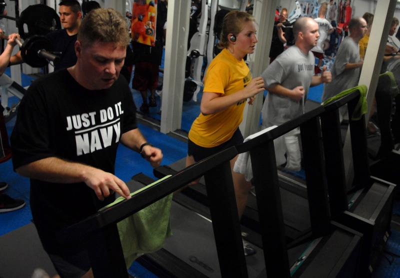 man, gym, stationary bike, social issues, fitness, police force, person, indoors, 2K, burn calories, using, olympic lifting platform, men, railing, prisoner
