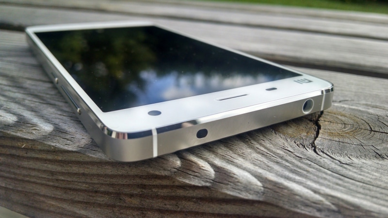 mobile phone, focus on foreground, smartphone, xiaomi, technology, arts culture and entertainment, smart phone, silver colored, outdoors, nature, wood - material