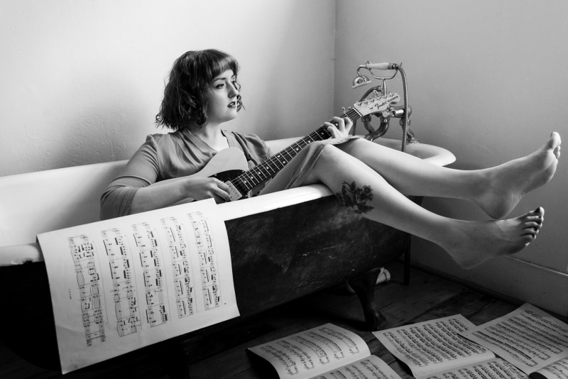 home interior, indoors, one person, real people, publication, 2K, sitting, text, communication, young adult, bathtub, reading, hairstyle, women, casual clothing